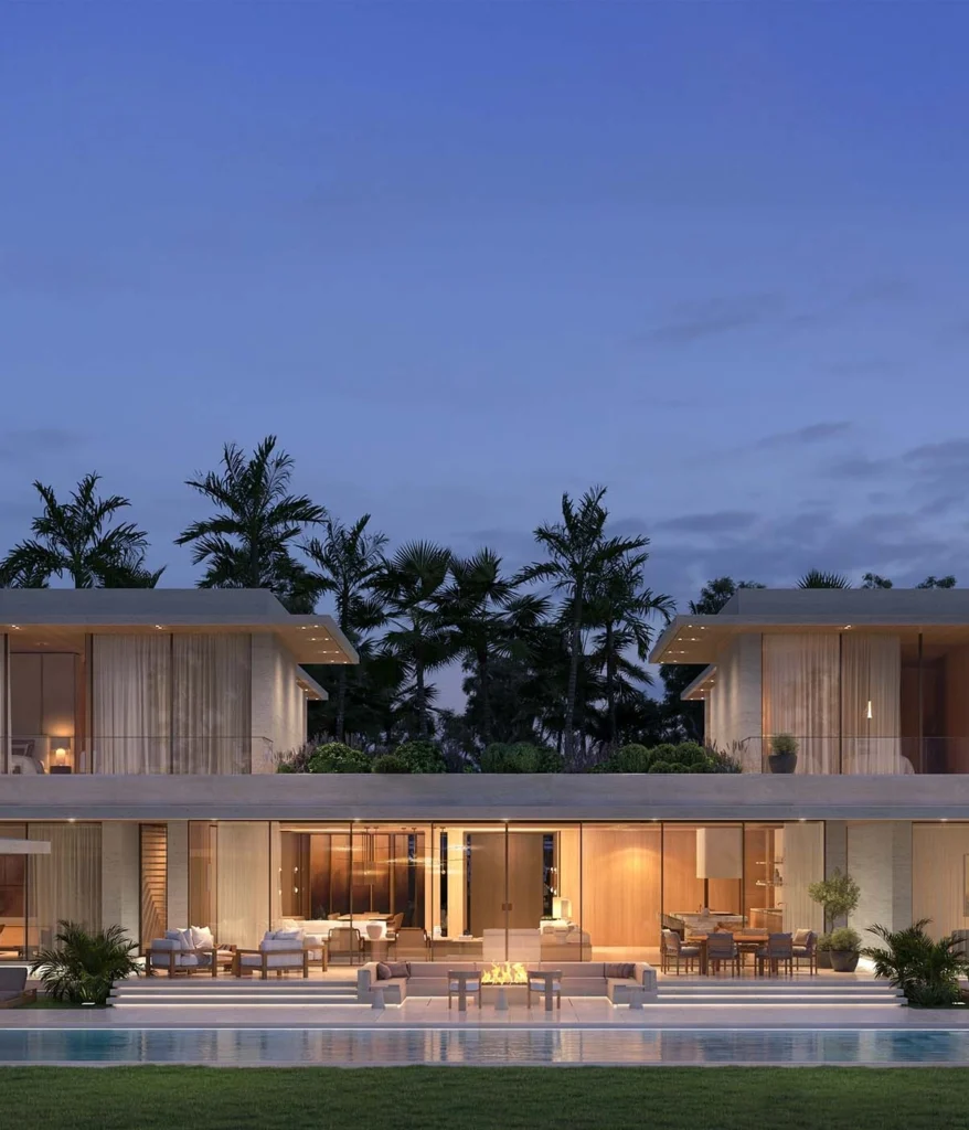 Illuminated twin luxury villa exterior with a large swimming pool, outdoor seating, and lush palm trees at night in Eden Hills Dubai.