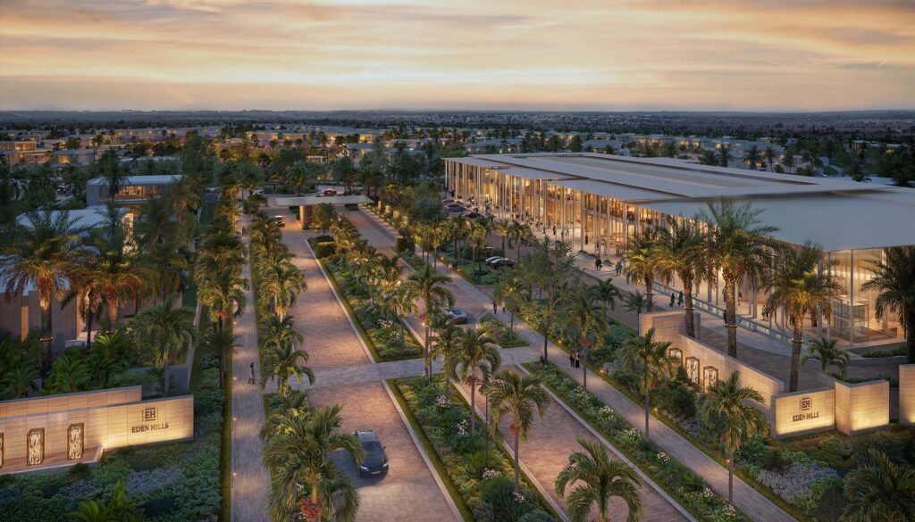 Panoramic view of the Eden Hills Dubai main entrance, palm-lined avenues, and luxury community facilities at sunset.